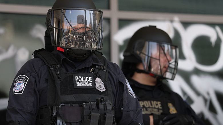 La policía de Aduanas y Protección Fronteriza de EE.UU. se encuentra frente al Edificio Federal, cubierto de grafitis tras las protestas provocadas por las redadas de inmigración en Los Ángeles, el 9 de junio de 2025.