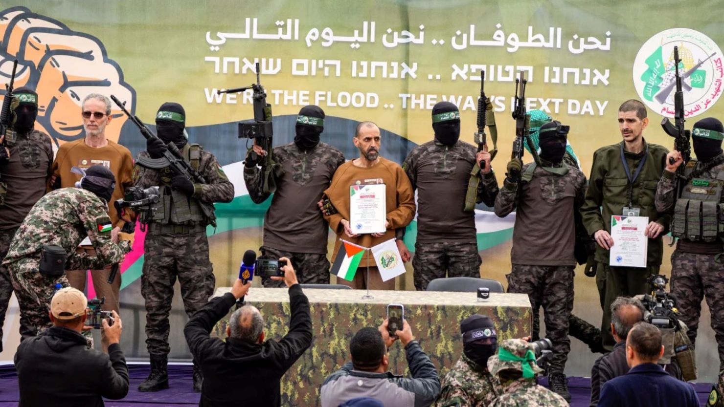 Los prisioneros israelíes Ohad Ben Ami, Eli Sharabi y Or Levy son presentados en un escenario antes de ser entregados a la Cruz Roja en Deir al-Balah, en el centro de de Gaza, el sábado.