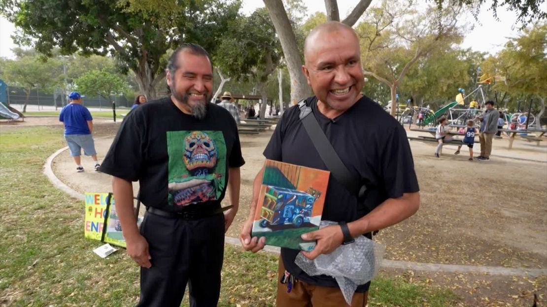 Ambrocio se muestra feliz junto a una pintura de su carro de paletas.