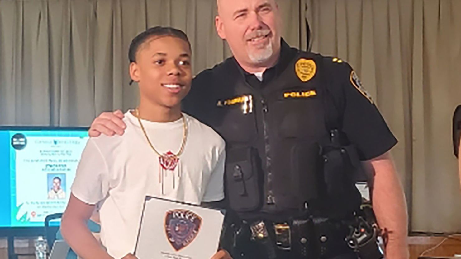 Acie Holland, 14, is pictured receiving an award from the local police department.