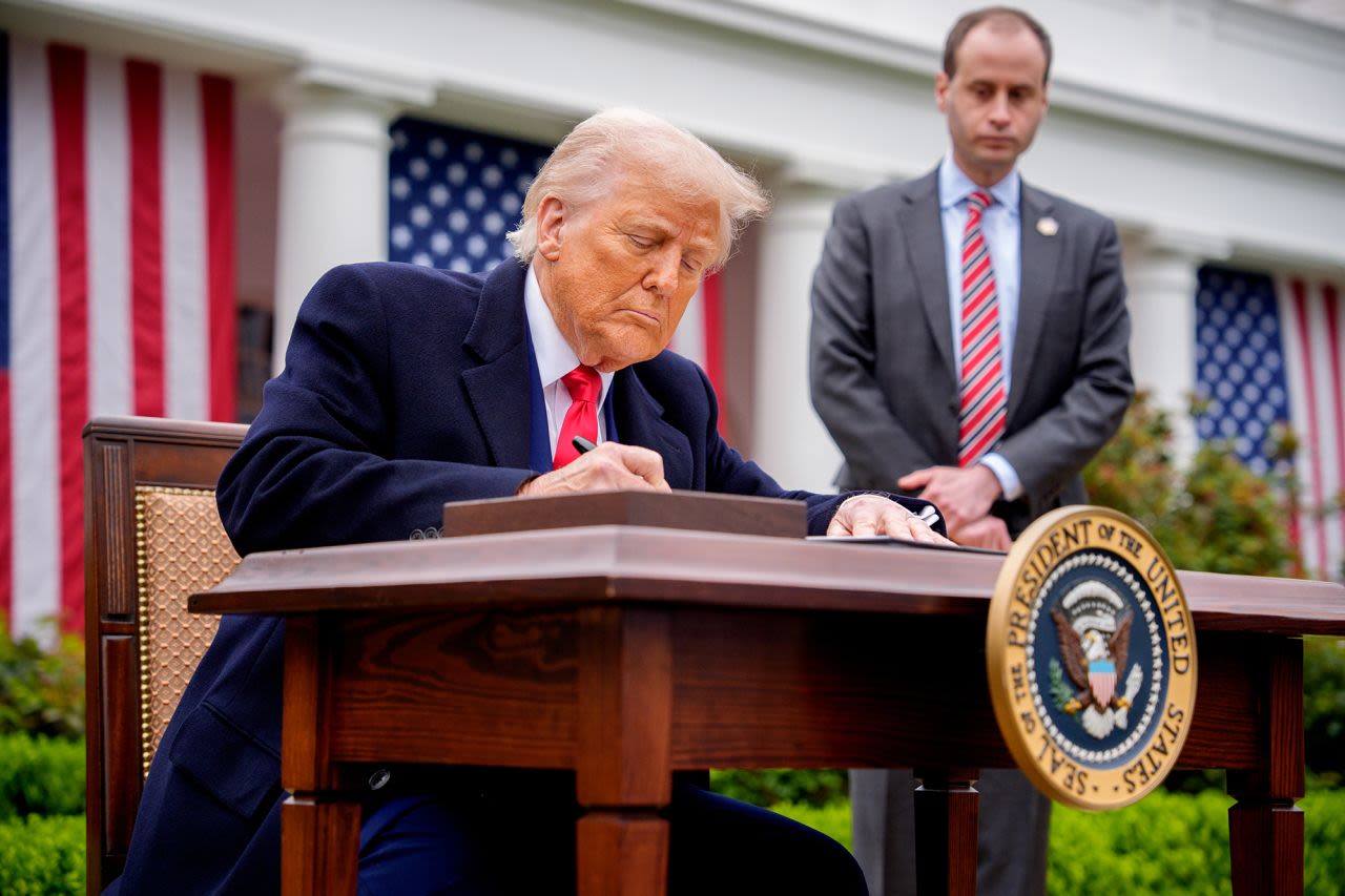 El presidente de EE.UU., Donald Trump, acompañado por el secretario de personal de la Casa Blanca, Will Scharf, firma decretos imponiendo aranceles en la Casa Blanca.