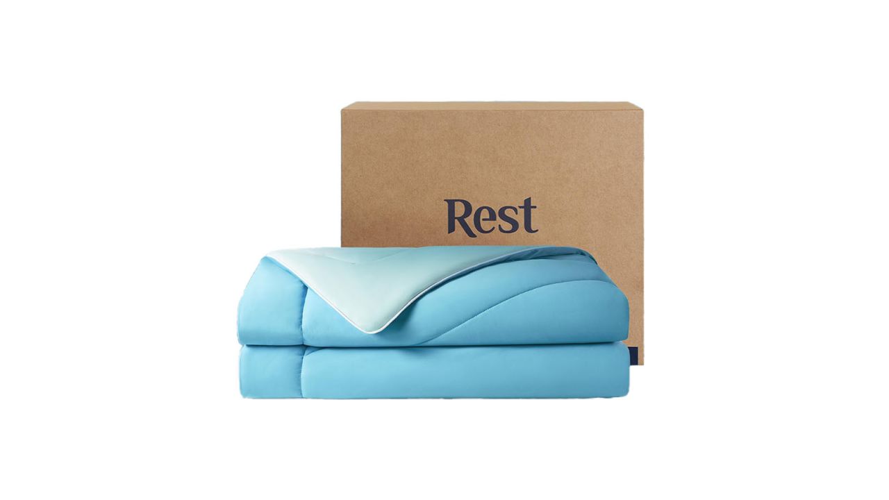 Blue cooling comforter in front of box with name "Rest" on it.