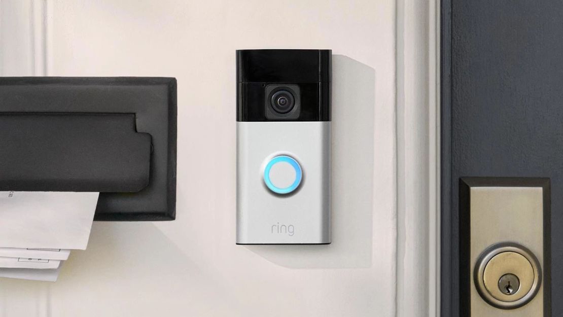 The new Ring Battery Doorbell mounted next to a front door with its button light on