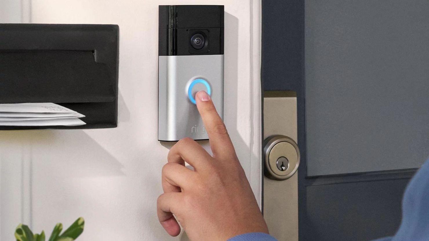 New Ring Battery Doorbell mounted at the front door with a person's hand pressing the button