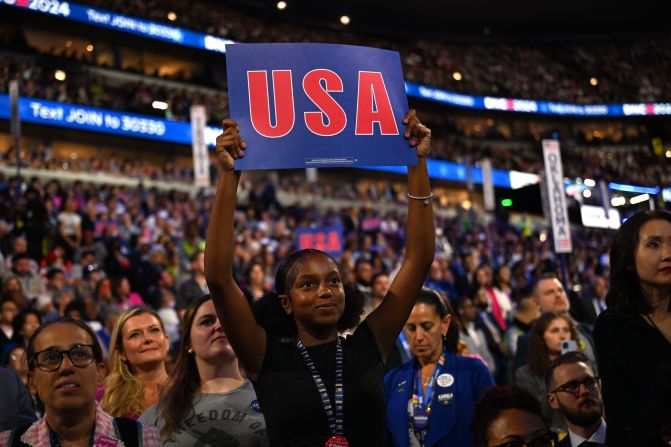 Rowan Curry holds up a USA sign on the convention floor on Wednesday.