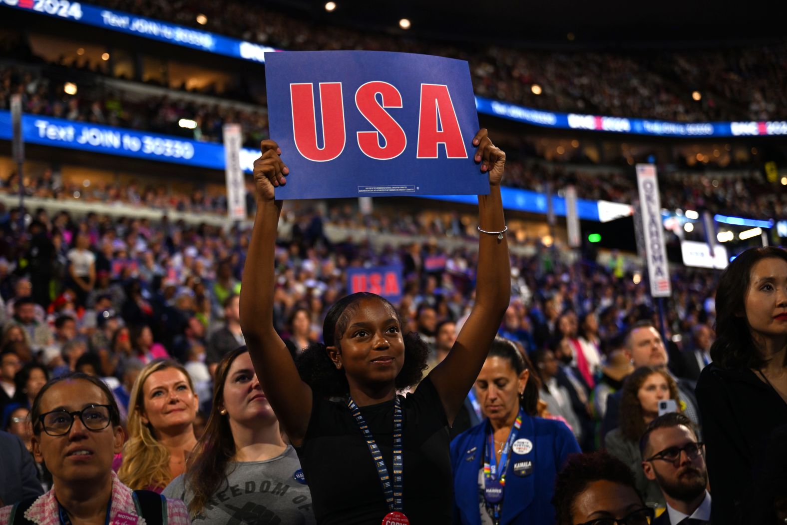 Rowan Curry holds up a USA sign on the convention floor on Wednesday.