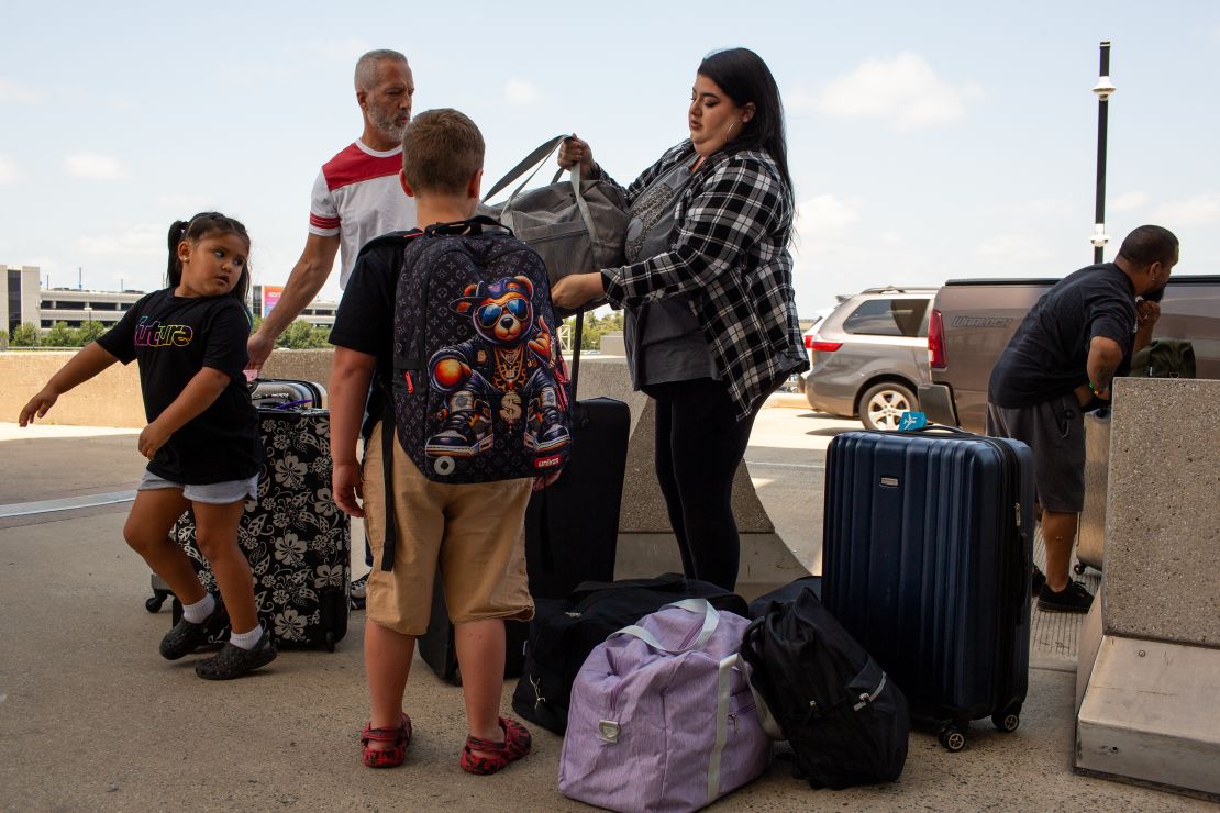 Suri, Graycen and Sasha unload luggage with Chris Welling at the Washington Dulles International Airport.
