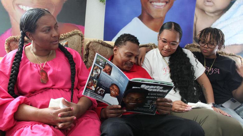 The Robinson family looks at photos of Yahushua Robinson, a 12-year-old boy who loved to sing, dance, and give everyone a smile.