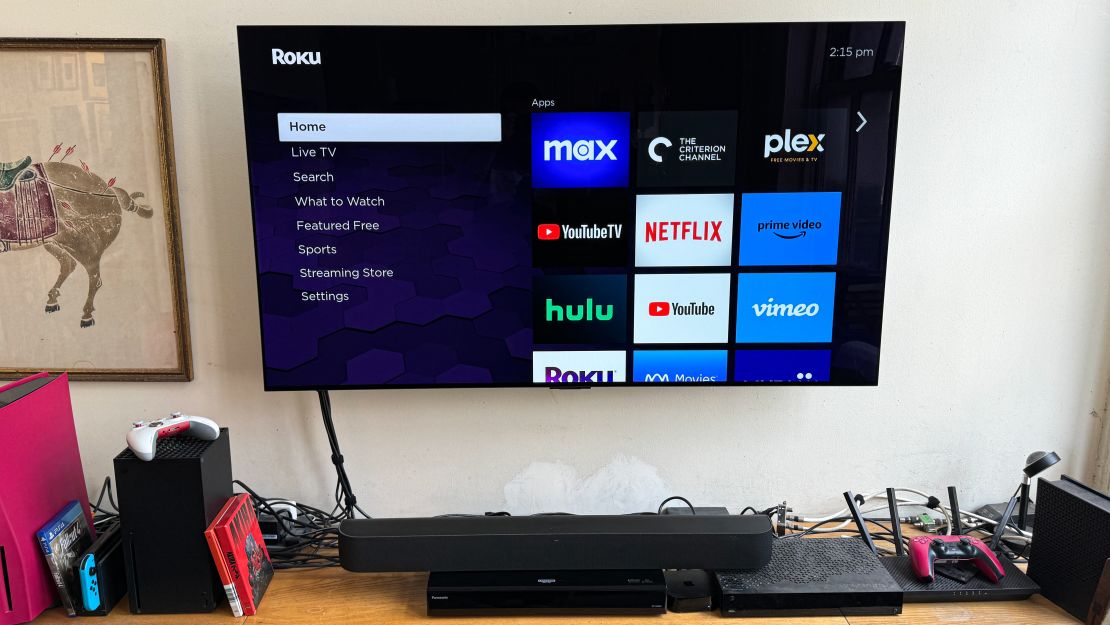 The Roku Streambar Pro sits under a TV showing the Roku home screen