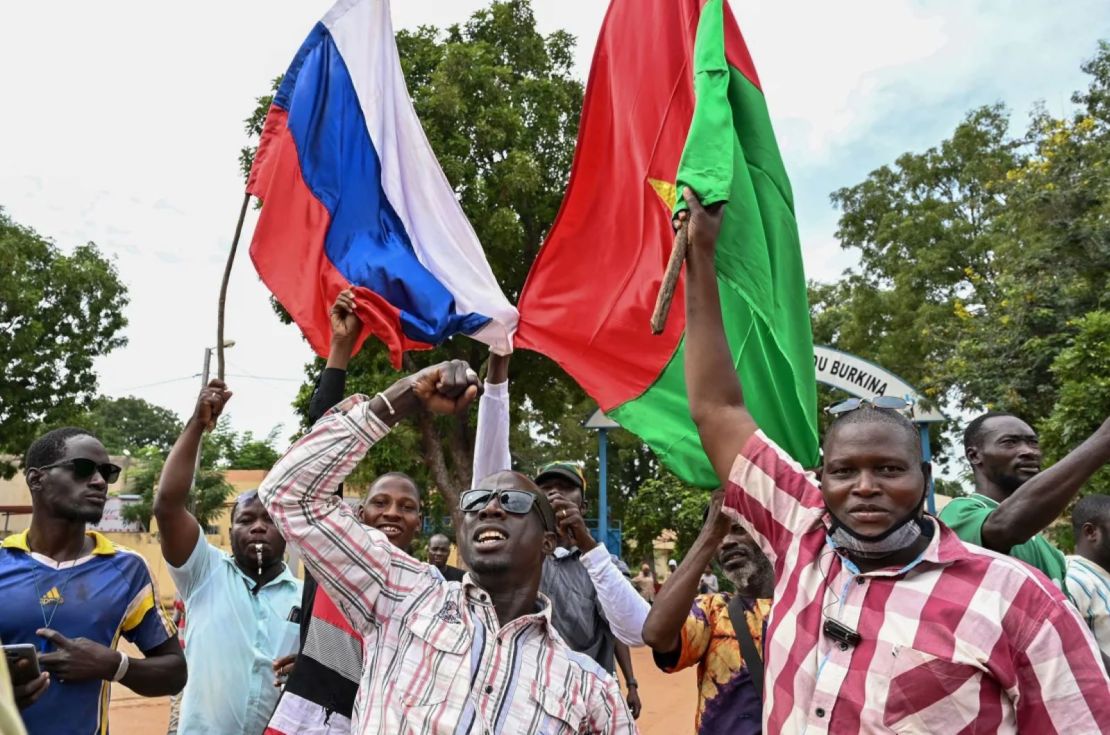 Seguidores del líder de la junta de Burkina Faso, Ibrahim Traoré, sostienen banderas nacionales de Burkina Faso y Rusia durante una manifestación en Uagadugú el 6 de octubre de 2022.