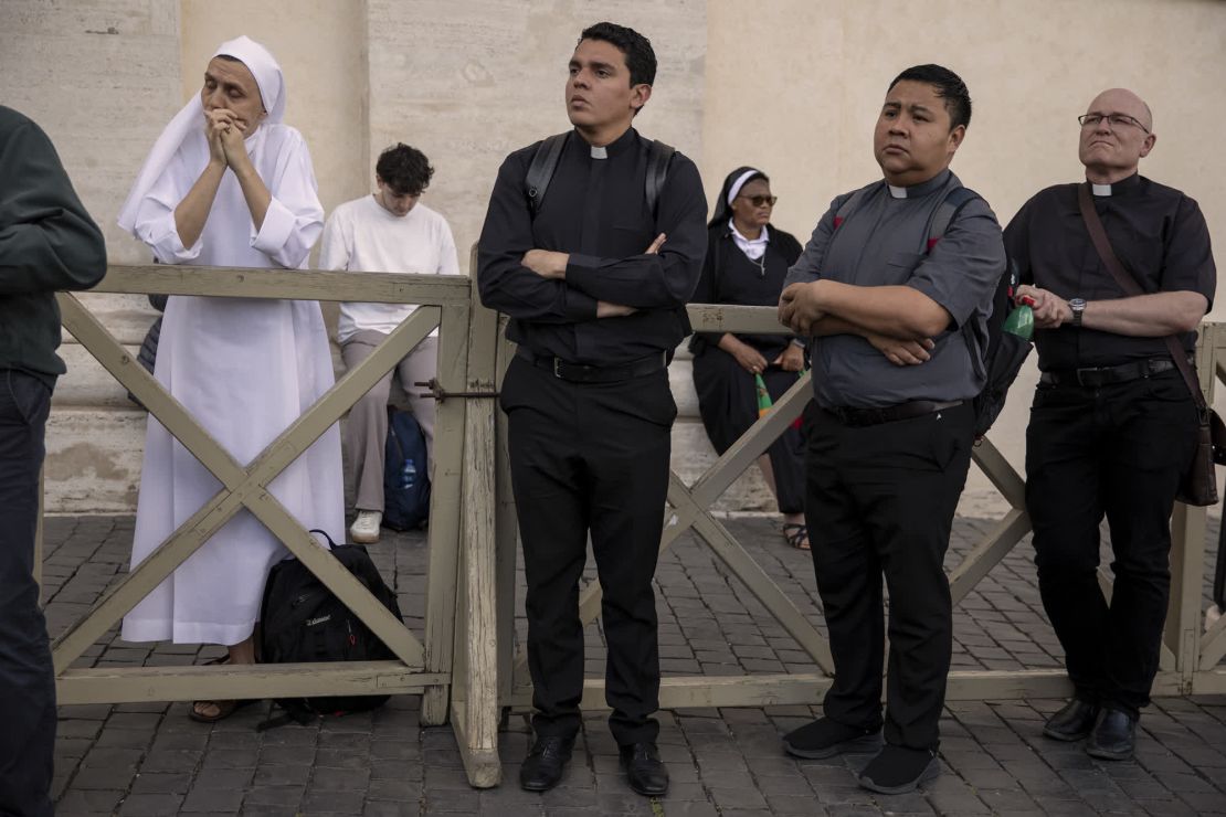 La gente se reúne en la Plaza de San Pedro en el primer día del cónclave.