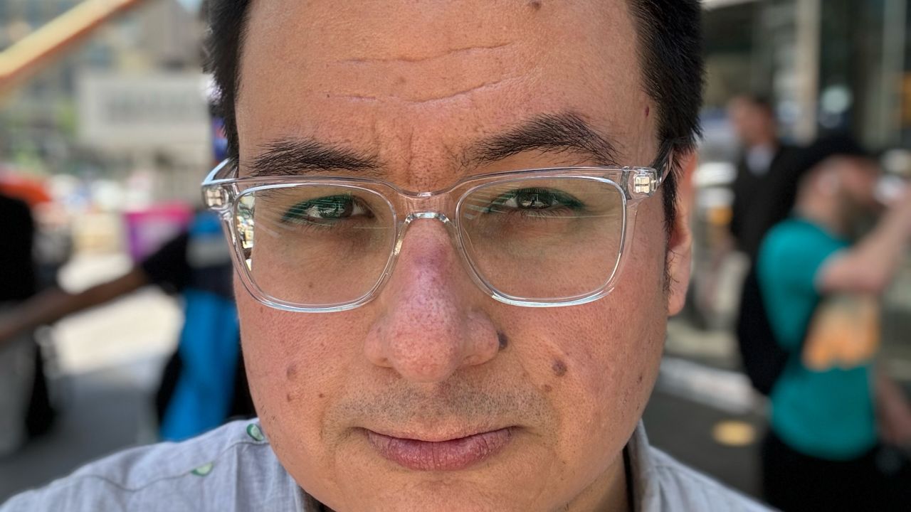 A Portrait Mode selfie of the author in a busy sidewalk, with the bokeh softening effect applied lightly to his hair and shirt.