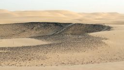 A view over the central sector of Saruq al-Hadid, showing the dark surface layer of copper slag that distinguishes the site from the surrounding desert landscape.