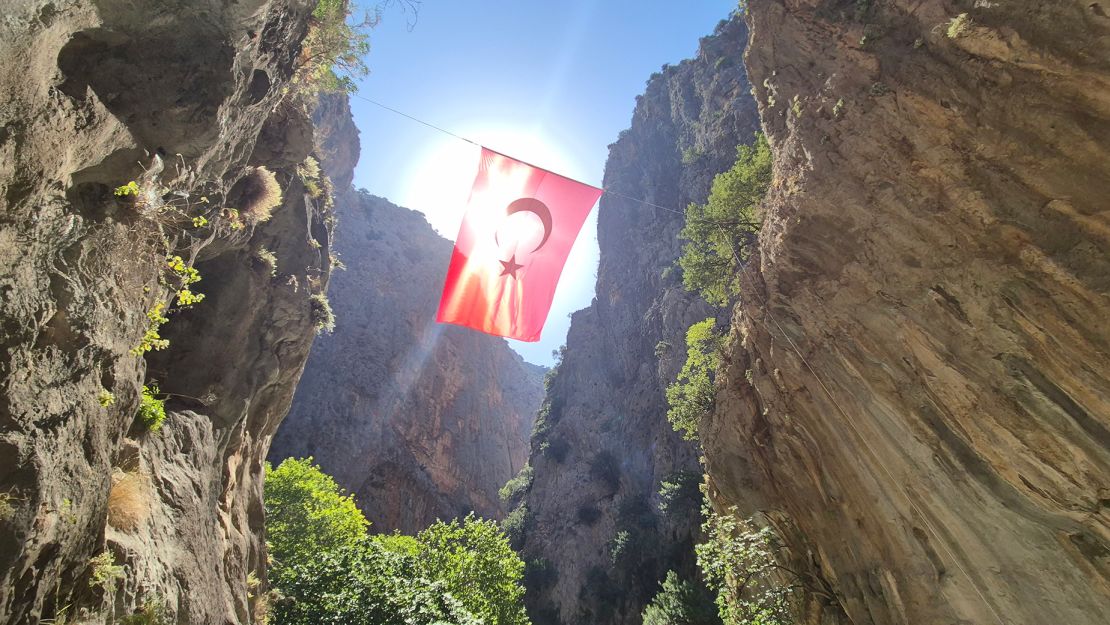 A gigantic Turkish flag flutters above the entrance to the gorge.