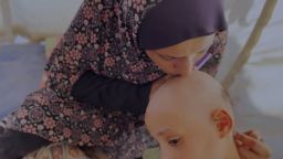La madre de Sama Tubail, Om-Mohammed, besa la cabeza de su hija.