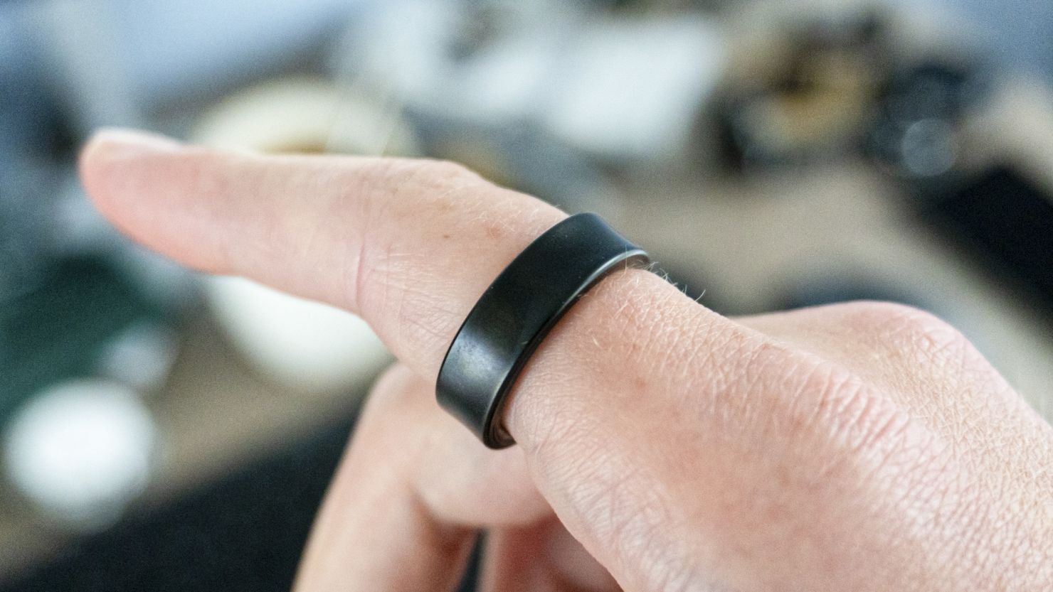 Finger pointing while wearing black Samsung Galaxy Ring.