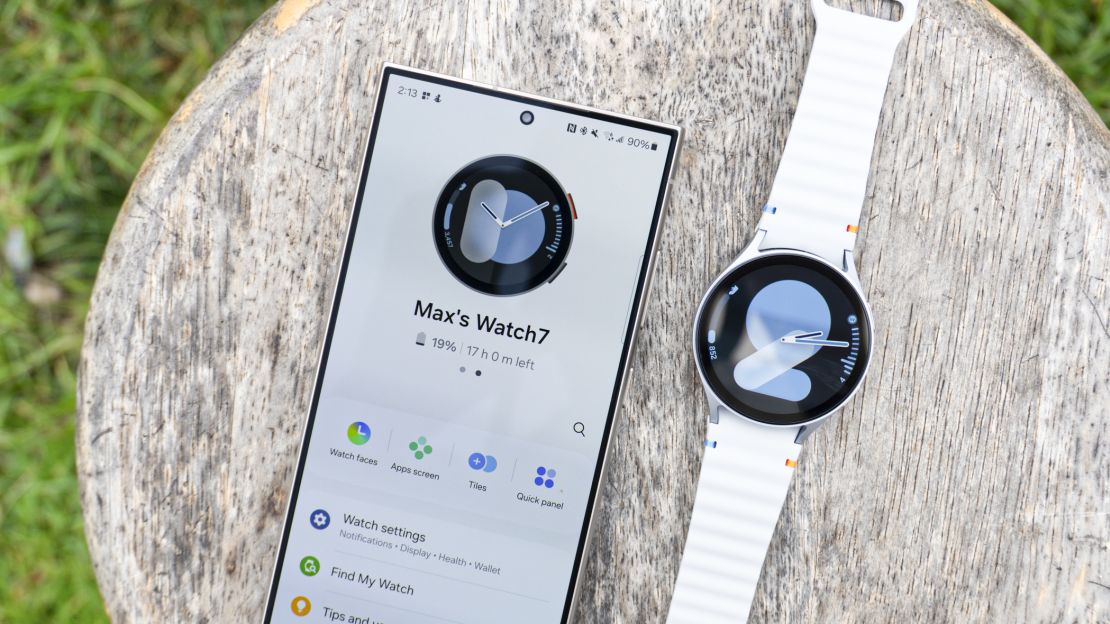 Samsung Galaxy Watch 7 on a table next to a phone showing the watch's app. 