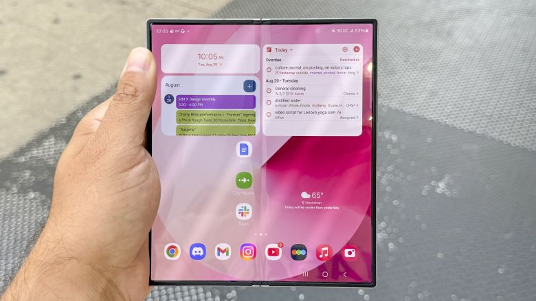 Samsung Galaxy Z Fold 6 opened to the home screen, in hand outside