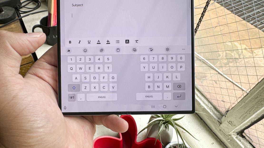 The Samsung Galaxy Z Fold 6 is iopen in hand and the split keyboard is up and broken out to the left and right sides of the screen