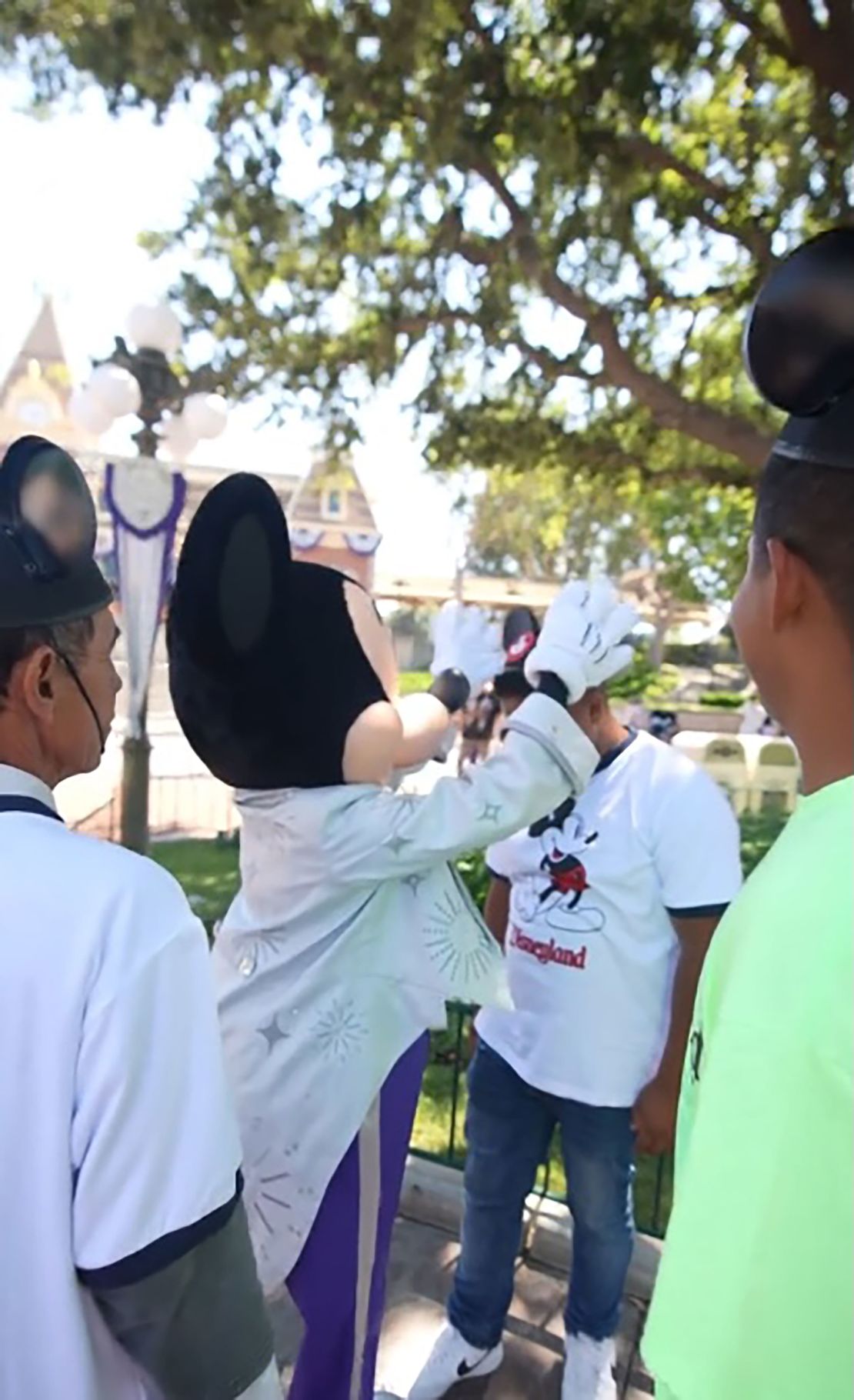 A screengrab from one of Jesús Morales' TikToks shows Mickey Mouse placing ears on a worker visiting the theme park.