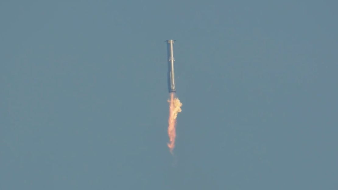 A still from SpaceX's live stream on Tuesday shows the Super Heavy rocket booster heading back to Earth for splashdown after the test flight team deemed conditions were not favorable for a catch attempt by the "chopsticks," or mechanical arms of a launch tower.