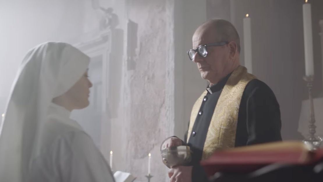A nun about to receive a potato chip from a priest in the commercial.