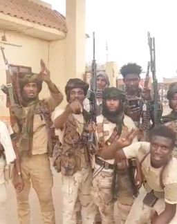 Armed men pose at the front gate of South Hospital in al-Fashir.