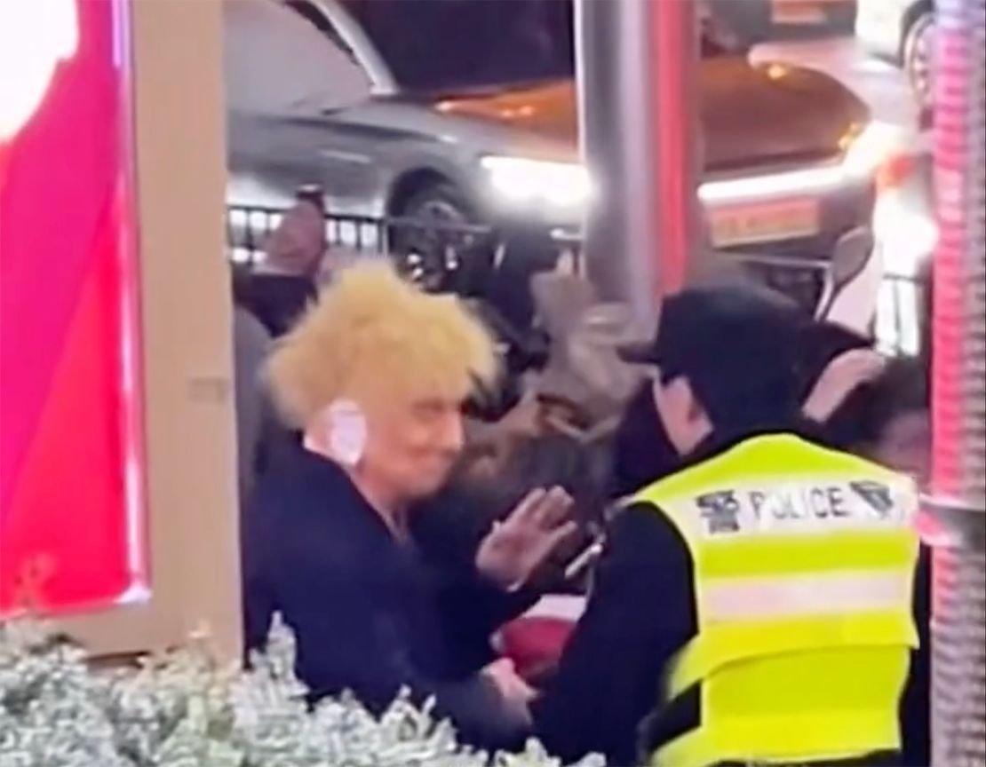 A reveler dressed as Republican presidential candidate Donald Trump is led away by police during Halloween celebrations in Shanghai on October 26, 2024.