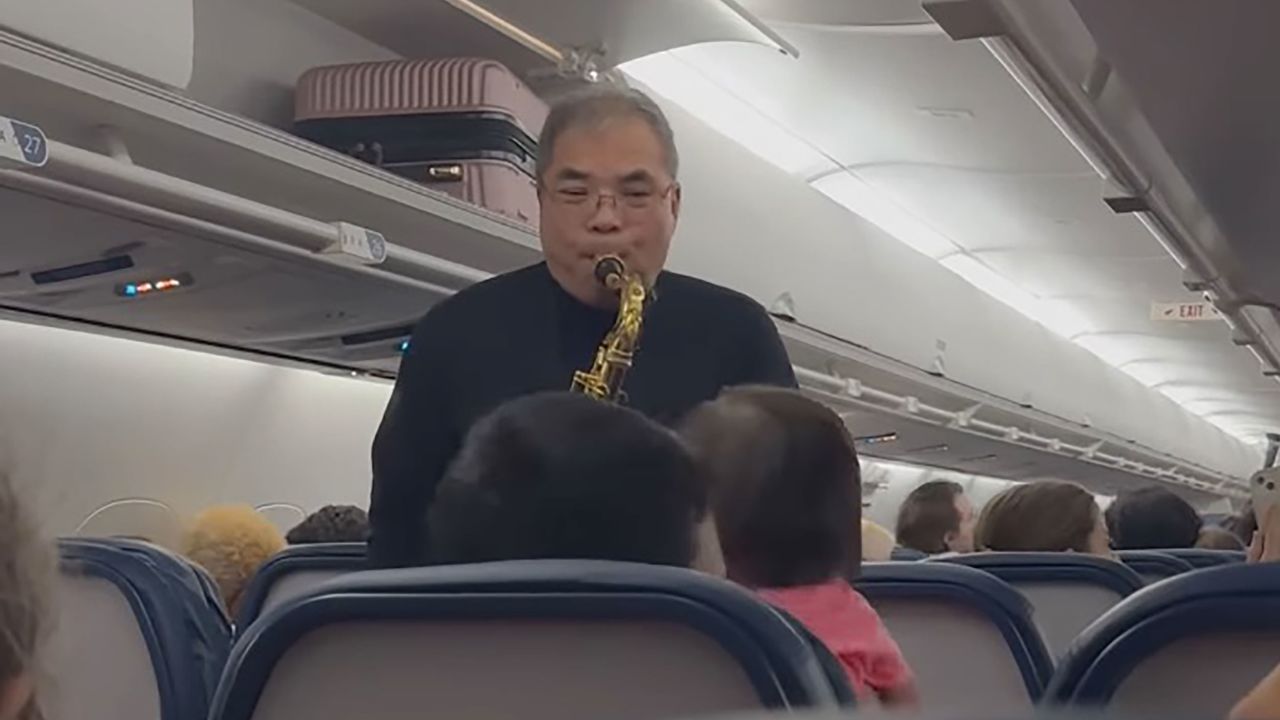 In a screengrab from a video posted to Facebook by Kate Dailey, Wayne Hoey performs for passengers on a delayed flight in Atlanta.