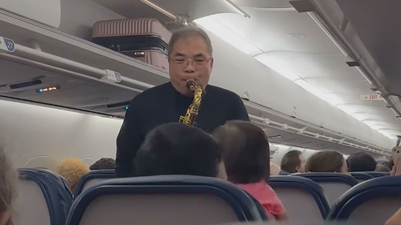 A flight was delayed in Atlanta for over an hour. A man got out his saxophone and played Christmas songs for fellow passengers