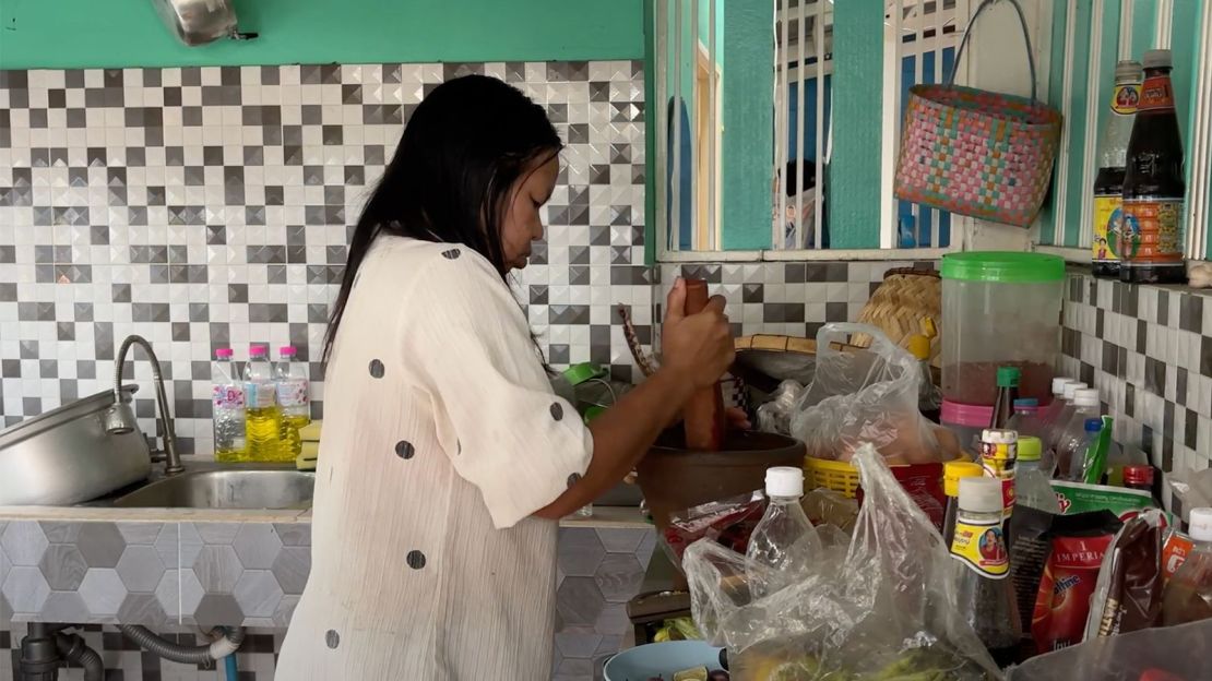 Surasak's mother, Kammee, prepares food ahead of the ceremony on February 15, 2025.