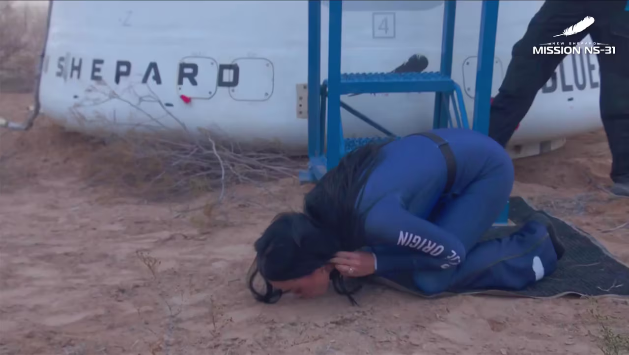 In this screenshot from video, Katy Perry kisses the ground after exiting the Blue Origin New Shepard capsule in West Texas, on Monday.