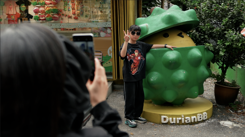 A visitor poses with a durian character at DurianBB Park in Malaysia.