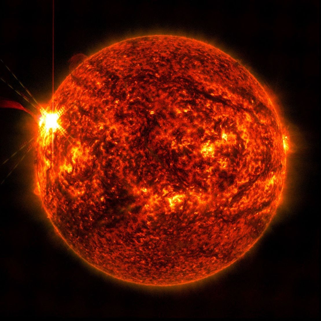 El Observatorio de Dinámica Solar de la NASA capturó esta imagen de una llamarada solar (vista como el destello brillante a la izquierda) el 14 de mayo. La imagen muestra un subconjunto de luz ultravioleta extrema que resalta el material extremadamente caliente en las llamaradas y que está coloreado en rojo.