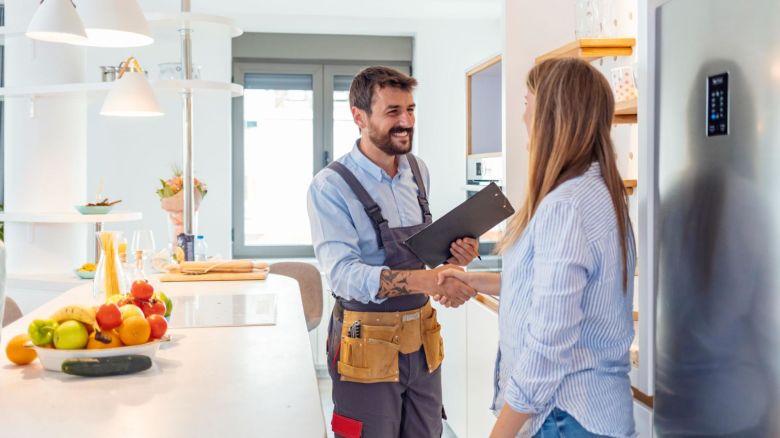 Homeowner and plumber shake hands after a service has been completed.