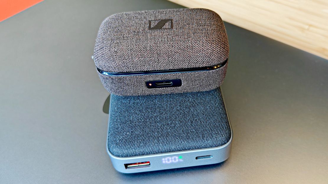 A closed Sennheiser Momentum True Wireless 4 case on a wireless charger.