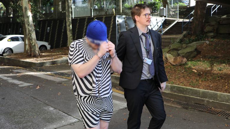 In this photo released by the NSW Police Force, police arrest a man following an investigation into an international satanic child sex abuse material ring November 27, 2025. Portions of this photo were blurred by the police force.