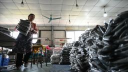 Una empleada clasifica prendas para la empresa china de comercio electrónico Temu en una fábrica de ropa de Guangzhou, China.