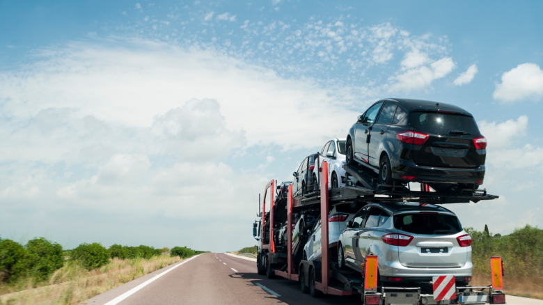 Cars being transported by open carrier