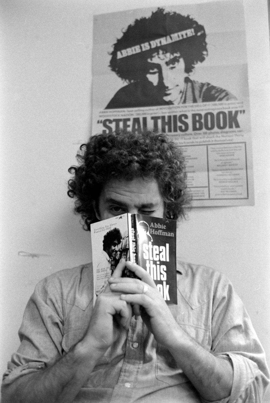 Abbie Hoffman holding a copy of 