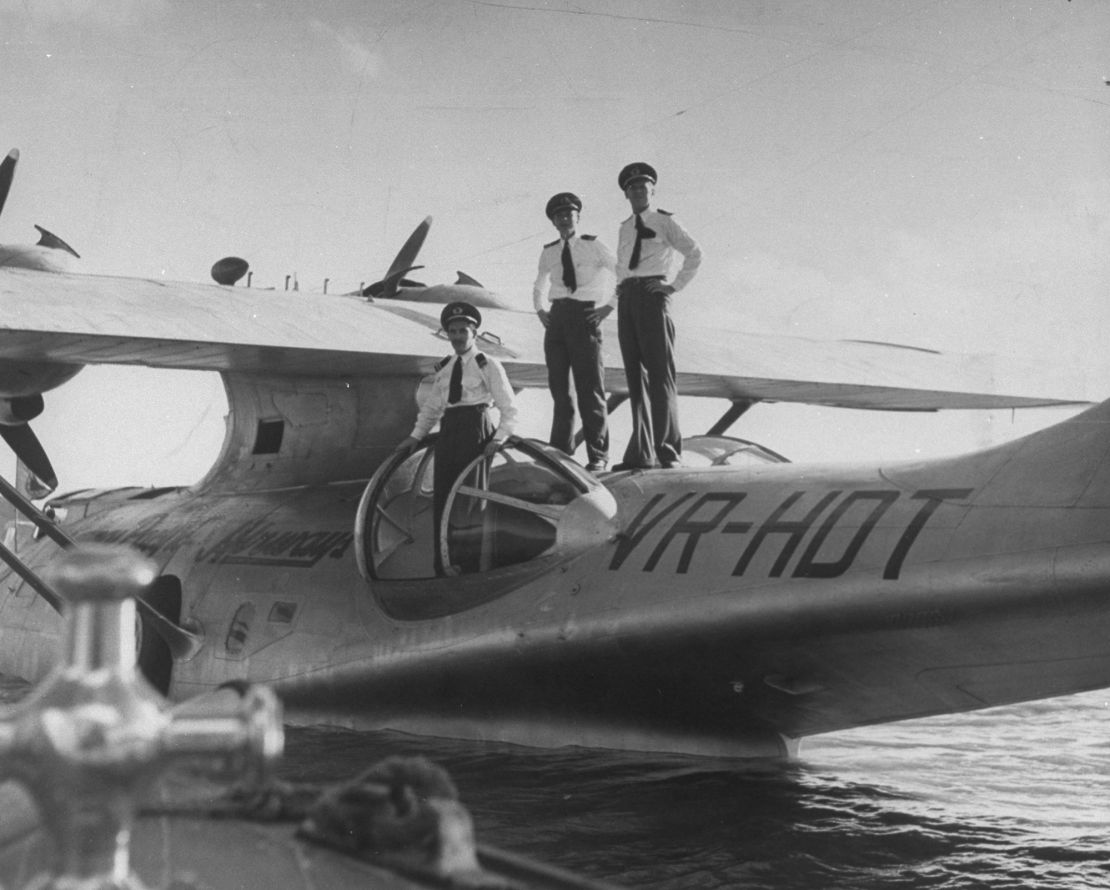 Pilot Dale Cramer (L) with his crew standing on their Catalina plane.
