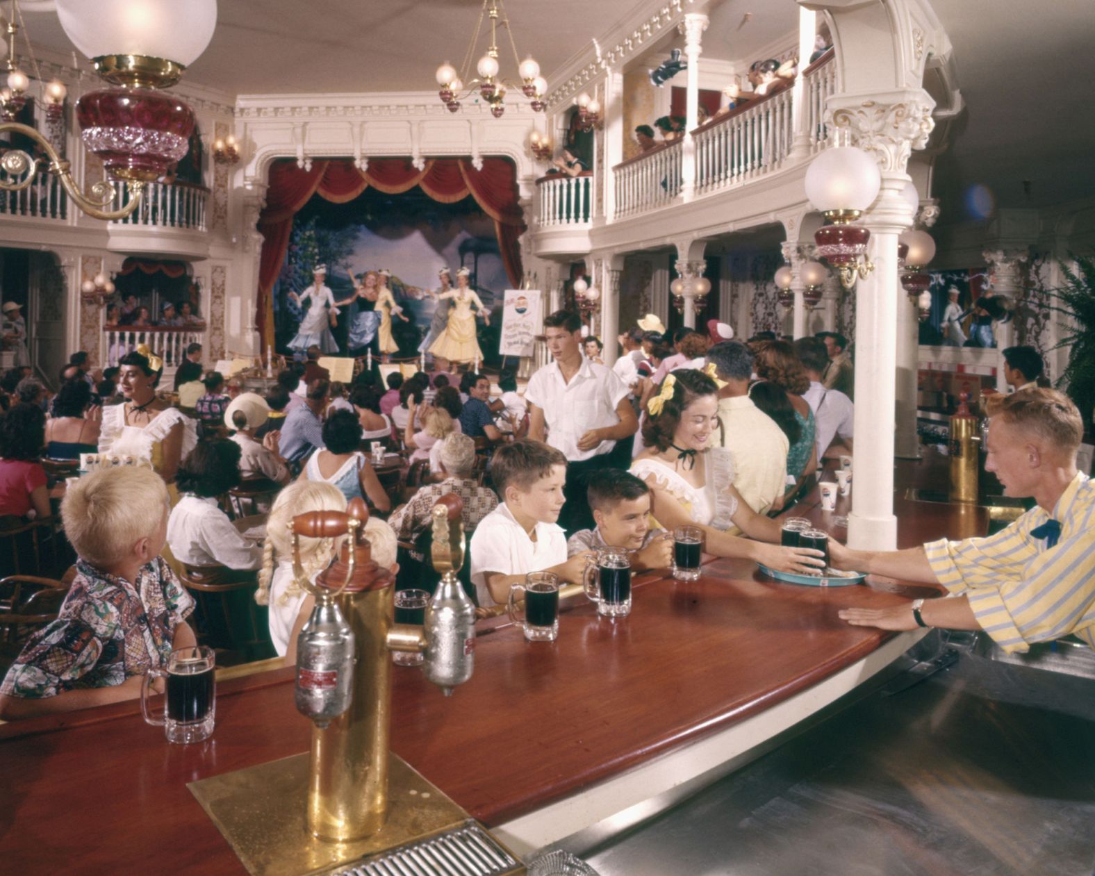 A bartender serves children in the Golden Horseshoe Saloon.