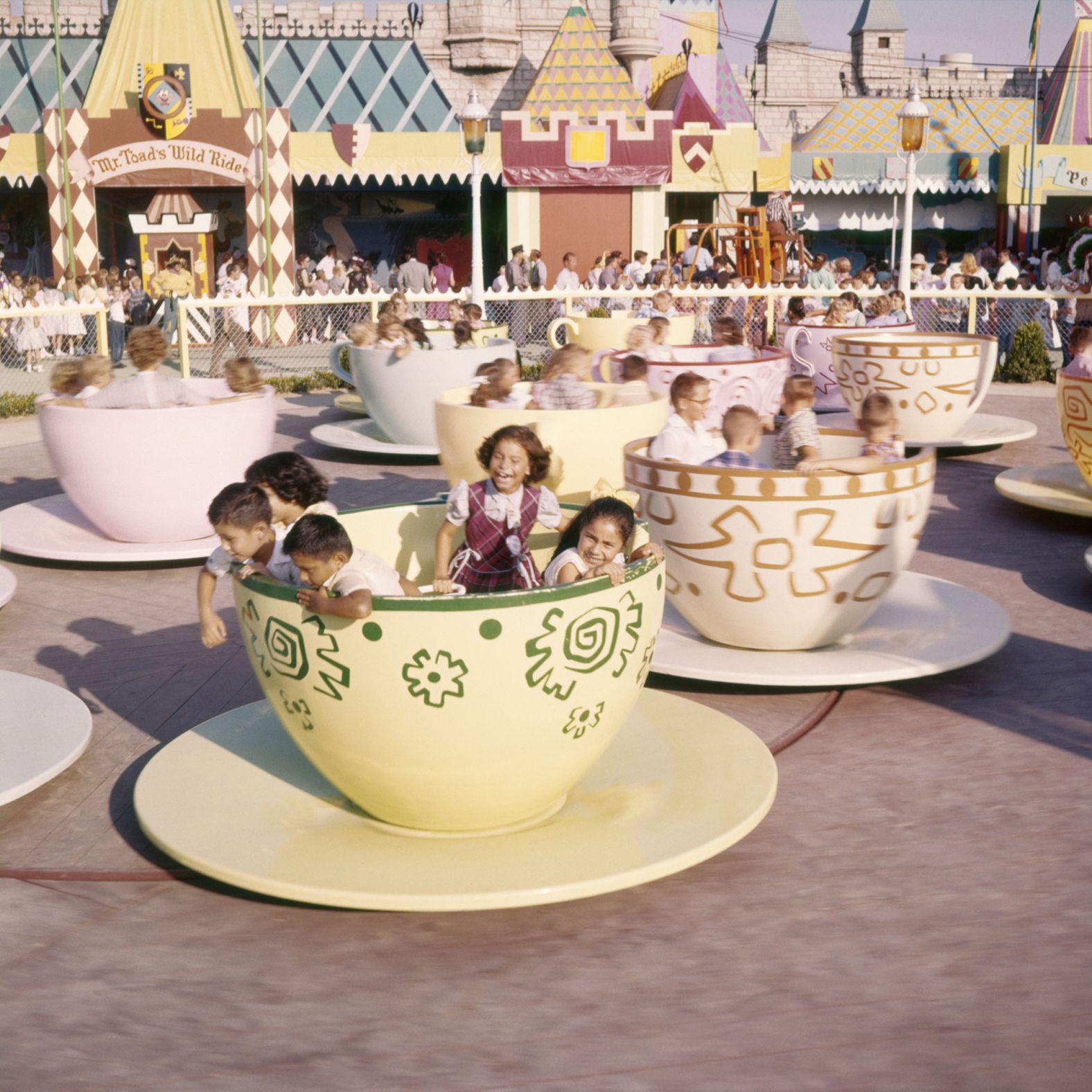 Children laugh inside the cups and saucers of the Mad Tea Party ride, which is based on the Mad Hatter tea party scene in "Alice in Wonderland."