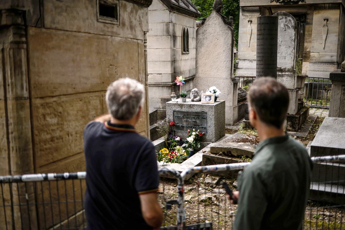 Visitors look at the grave of Jim Morrison at the Pere Lachaise cemetery in Paris, France, on July 1, 2021, two days before the 50th anniversary of the singer's death.