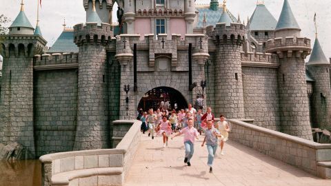 Children run through gate of Sleeping Beauty's Castle at Disneyland in Anaheim, California, on opening day.