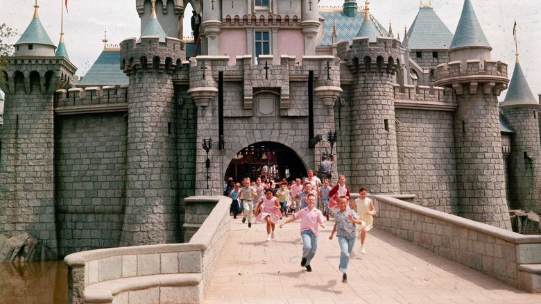 Children run through gate of Sleeping Beauty's Castle at Disneyland in Anaheim, California, on opening day.