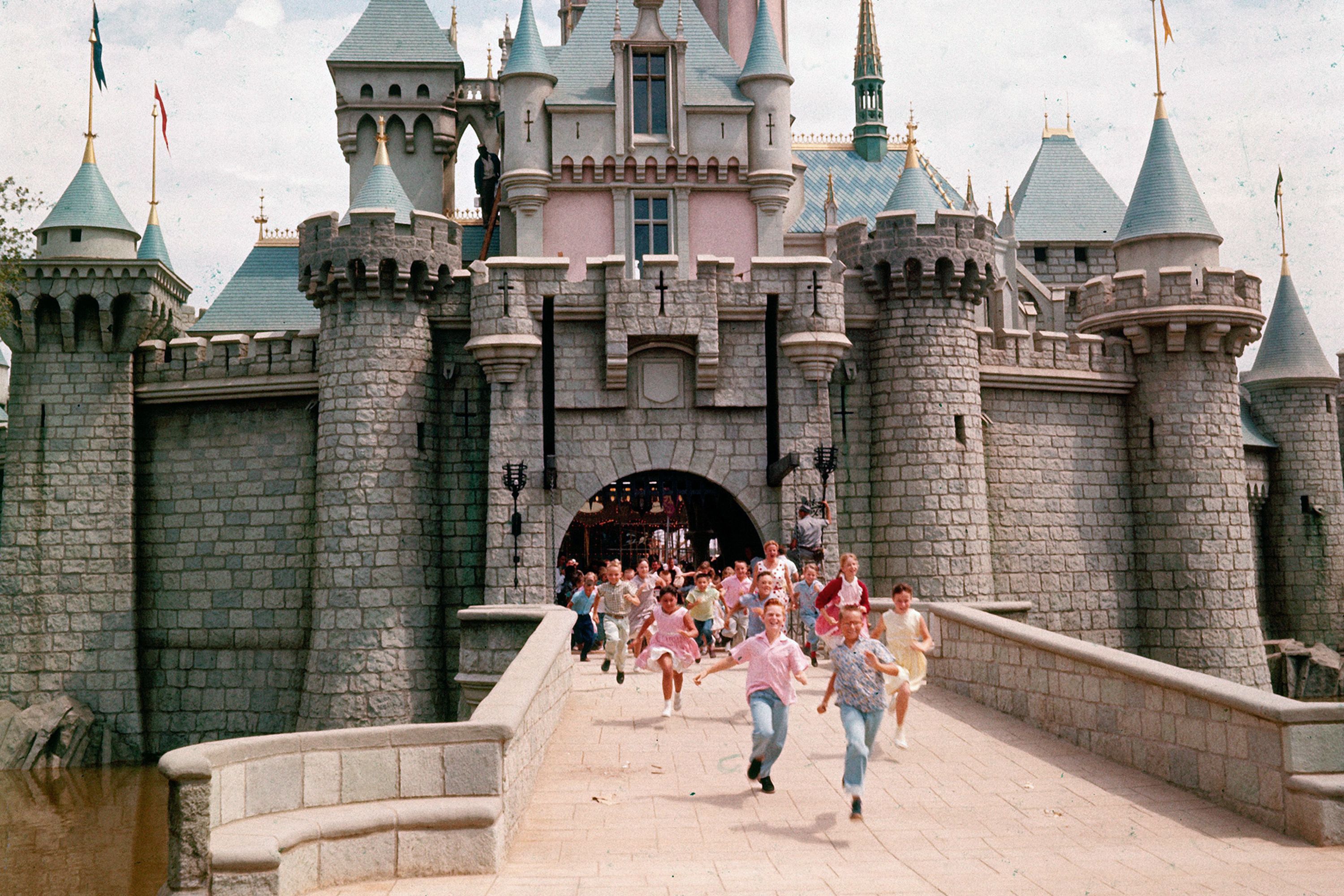 Children run through the gateway of Sleeping Beauty Castle on Disneyland's opening day in Anaheim, California, on July 17, 1955.