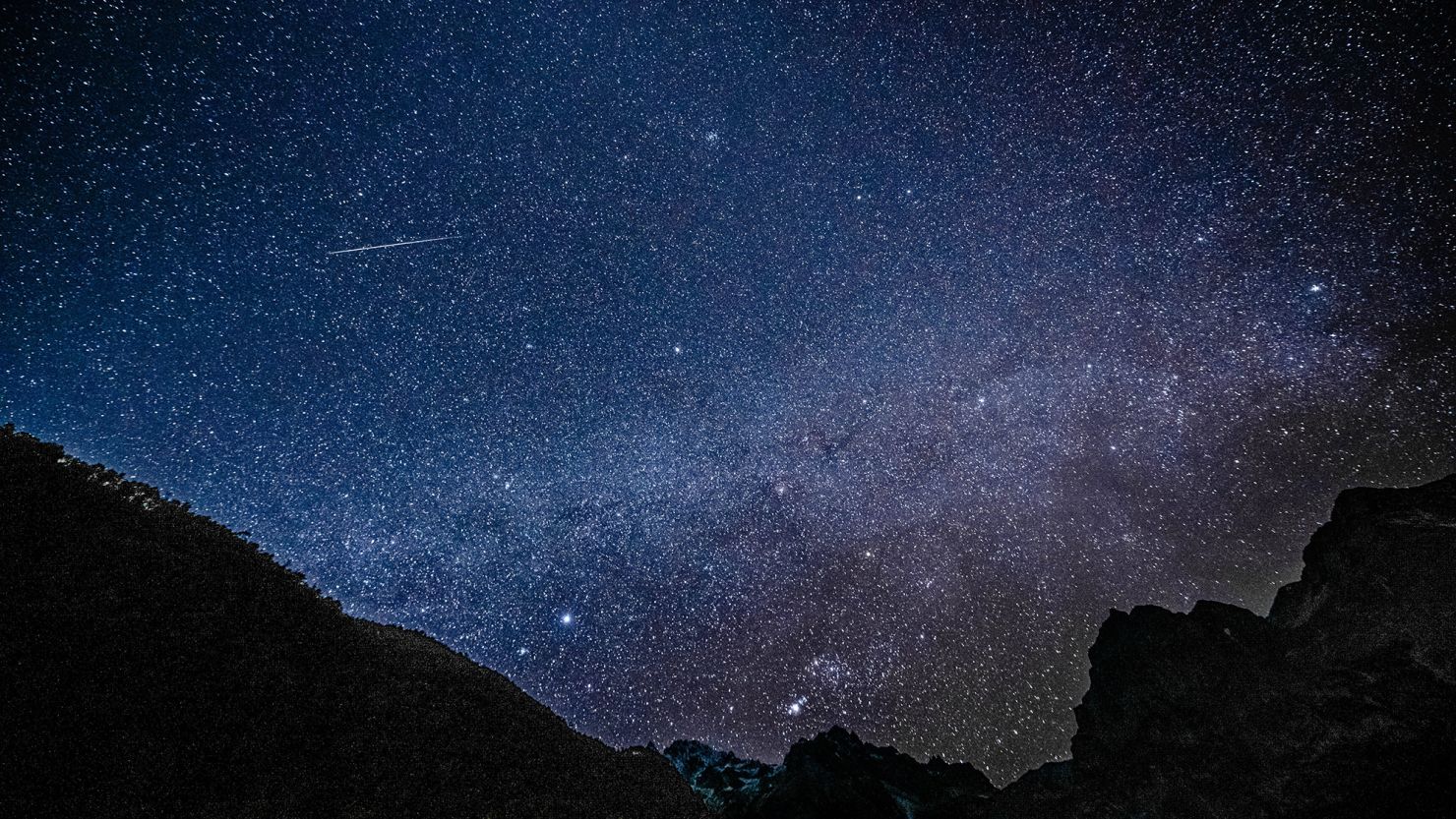 A Geminid meteor is seen streaking across the sky at the Yulong Snow Mountain in southwest China in 2021. This year, the Geminids will peak on Thursday.