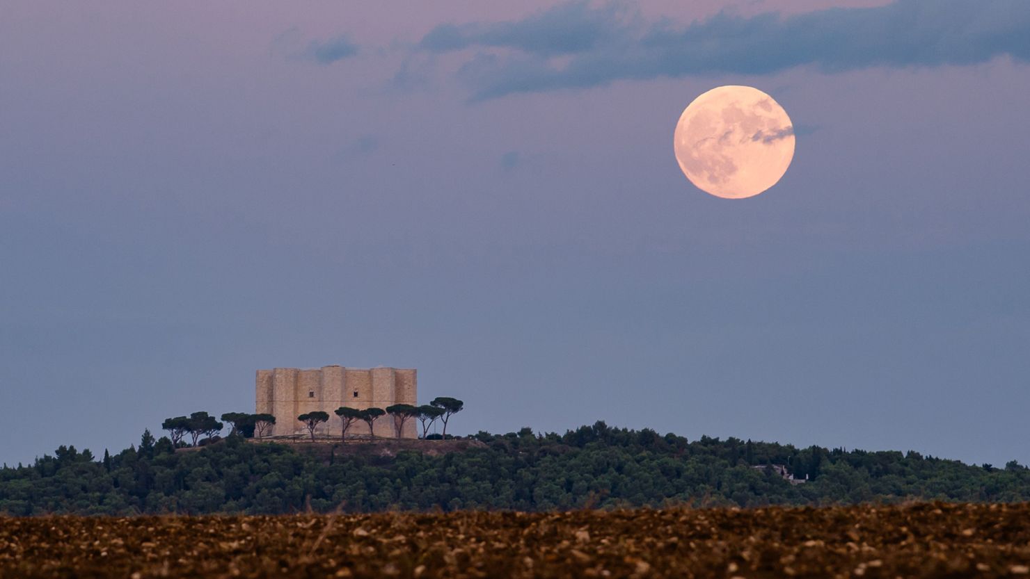 The full hunter's moon rises behind Castel del Monte in Andria, Italy, on October 28, 2023.