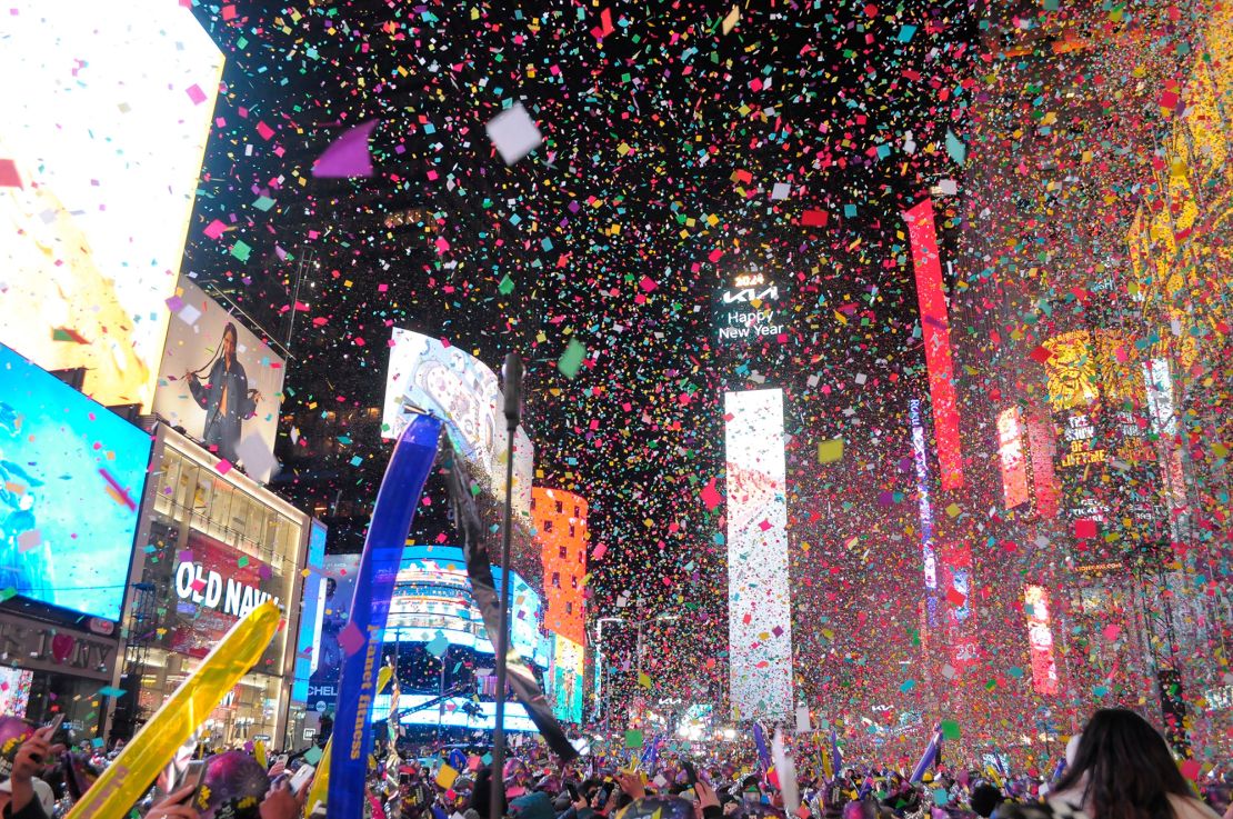 Revelers celebrate under falling confetti and bright lights after the New Year's Eve ball drop in Times Square in Manhattan.